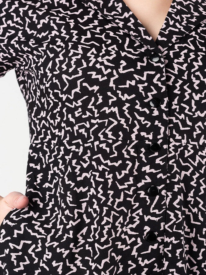 Vestito Volcom Stormy Tropix con stampa tropicale e chiusura a bottoni, ideale per un look estivo casual e chic.